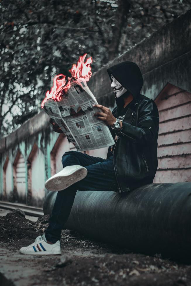man-wearing-mask-sitting-down-and-holding-newspaper-with-1852389
